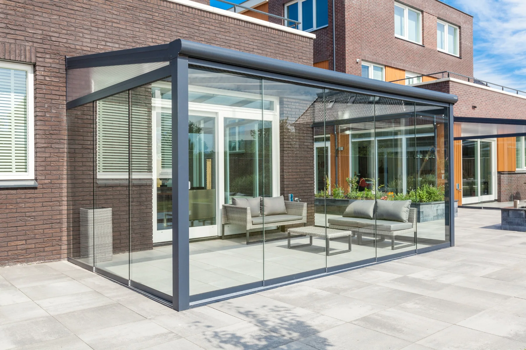 Sommergarten mit Glasschiebewänden als modulare Erweiterung einer Terrassenüberdachung